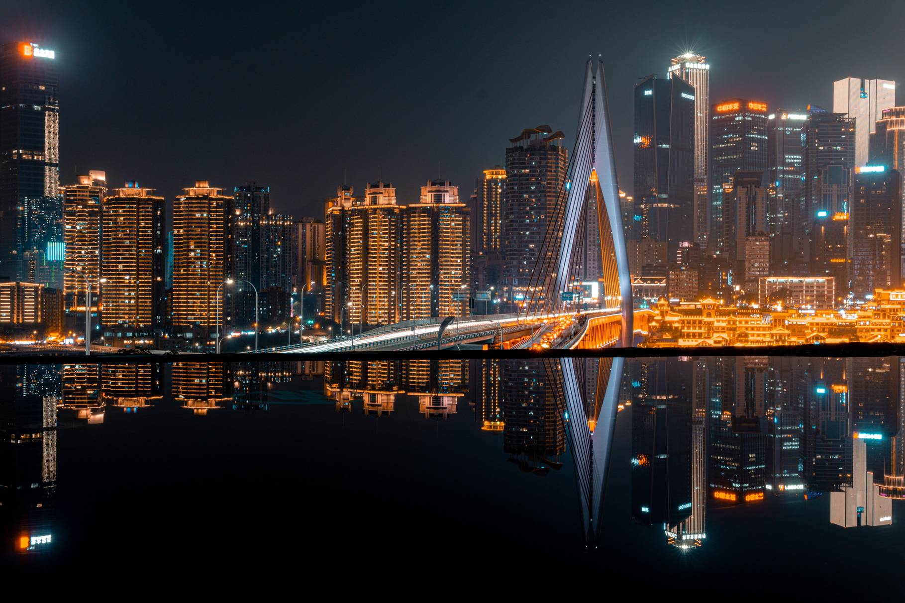 Bürohochhäuser einer Stadt bei Nacht, im Wasser reflektiert